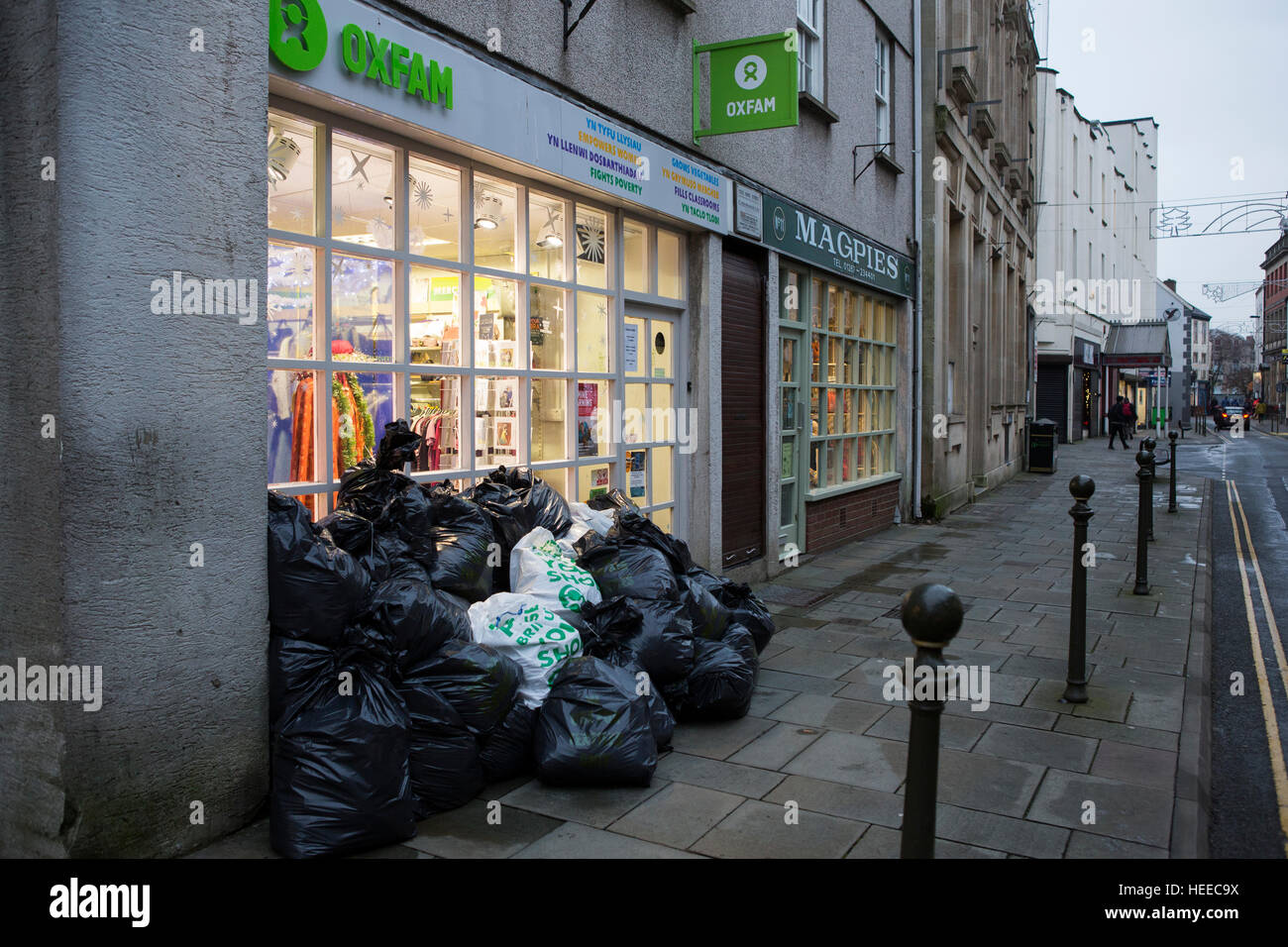 Ein großer Haufen von Elementen wartet draußen ein Oxfam-Charity-Shop auf der Straße in den frühen Morgenstunden Stockfoto