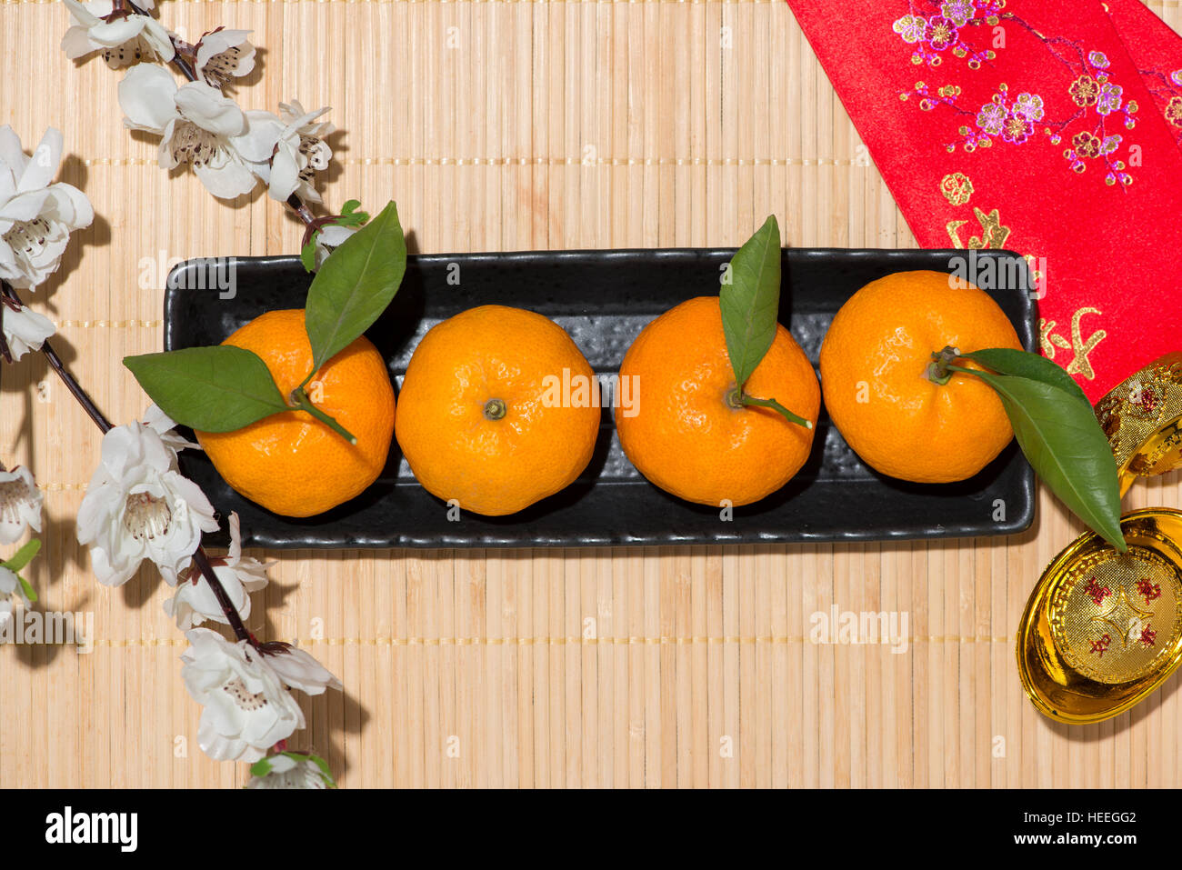 Mandarinen und Lunar New Year mit Text "Frohes neues Jahr" auf rote Tasche. Tet Ferienkonzept. Stockfoto