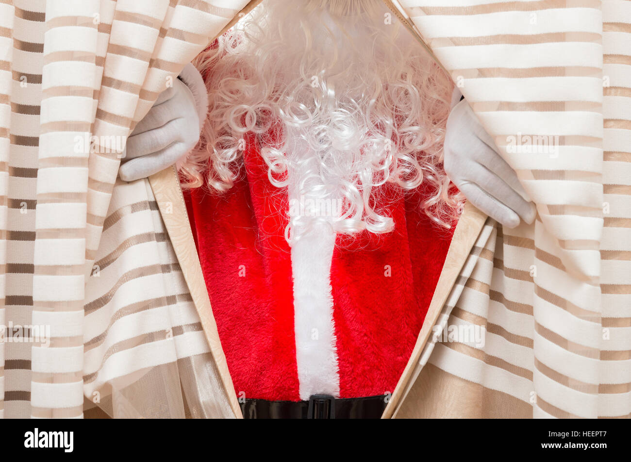 Santa Claus auftauchend von Vorhängen Stockfoto