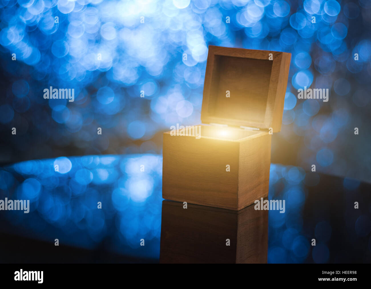 Offenen Holzkiste mit magischen Licht innen, beleuchtete blaue Bokeh Hintergrund Stockfoto