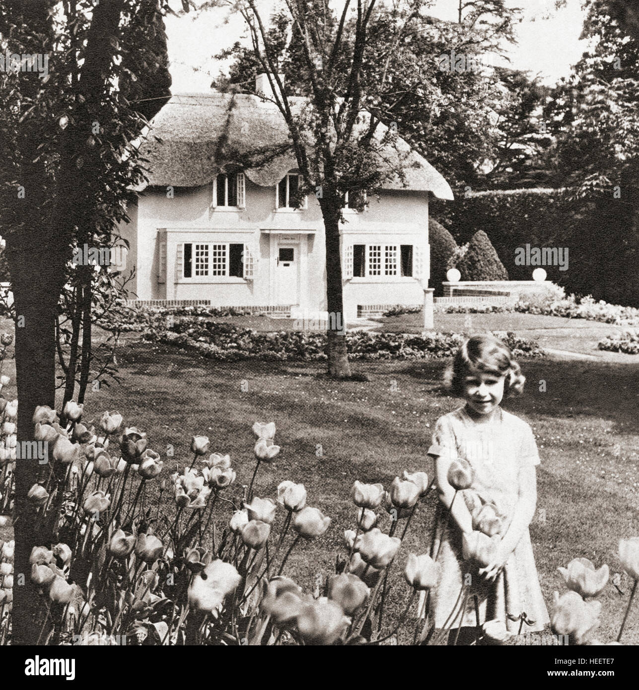 Prinzessin Elizabeth im Y Bwthyn Bach oder dem kleinen Haus, gelegen im Garten der Royal Lodge, Windsor Great Park, Berkshire, England. Dieses Miniaturhaus war ein Geschenk der Einwohner von Wales an sie. Prinzessin Elizabeth, zukünftige Königin Elizabeth II., hier im Alter von neun Jahren gesehen. Elizabeth II, 1926 - 2022. Königin des Vereinigten Königreichs, Kanada, Australien und Neuseeland. Stockfoto