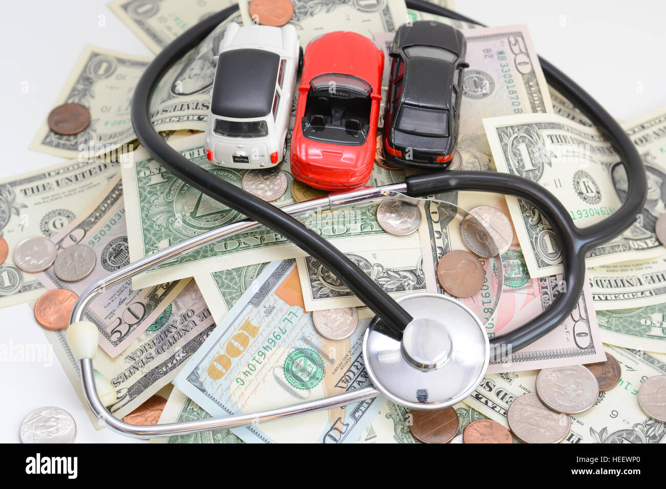 Automobilindustrie-Analyse-Konzept mit Spielzeugautos und Stethoskop auf Geld Stockfoto