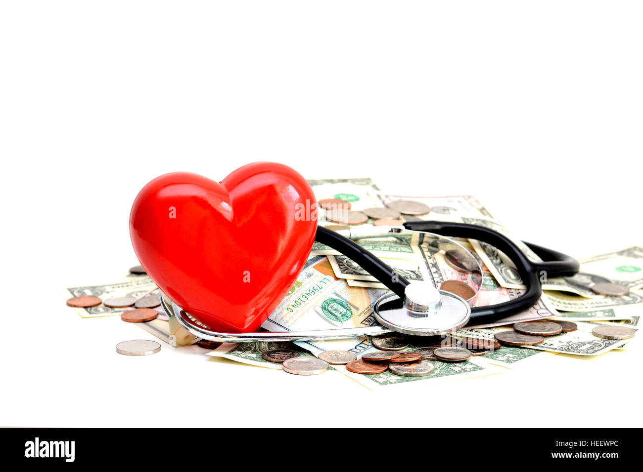 Rotes Herz und Stethoskop ruht auf Haufen von Dollar Stockfoto
