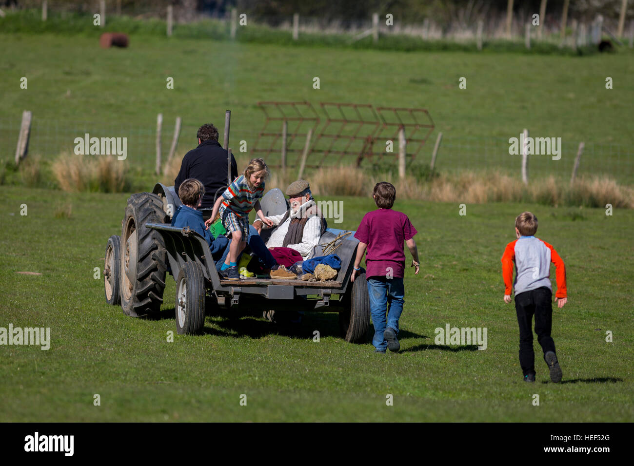 Eine Familie auf einem traditionellen Traktorfahrt unter ein Landwirt Felder in Kent im späten Frühjahr, UK. Stockfoto