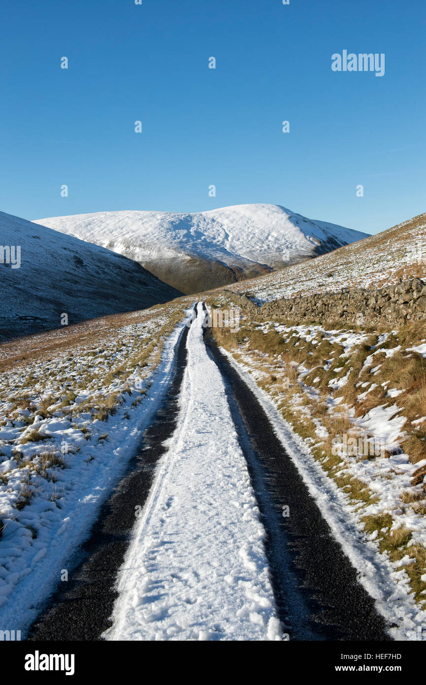 Frost und Schnee bedeckt Talstrasse mit Tracks in den Scottish Borders. Schottland Stockfoto