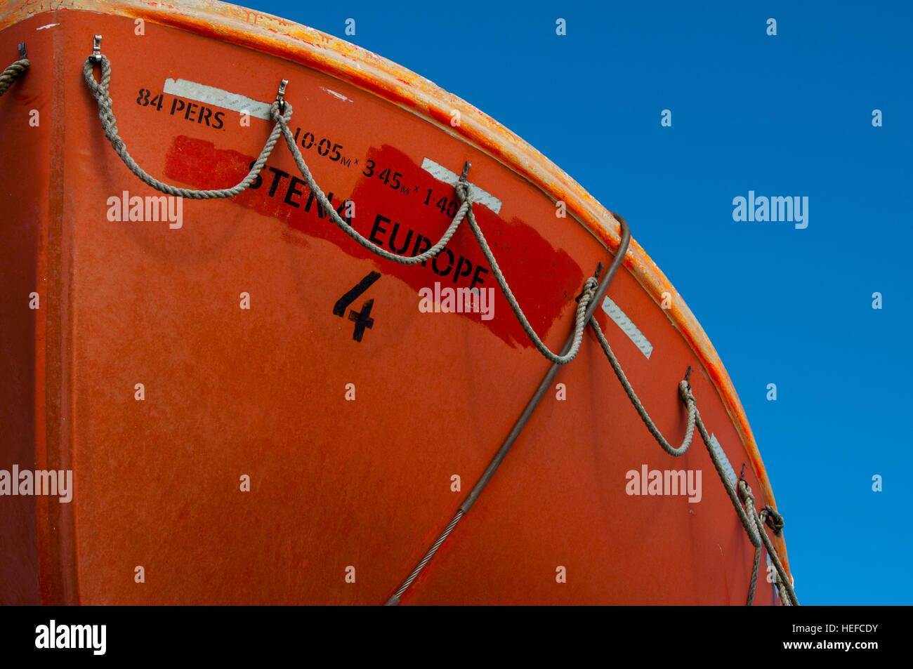 Stena Europe bringt ein orangefarbenes Rettungsboot gegen den blauen Himmel Stockfoto