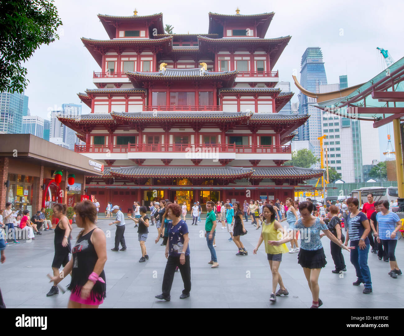 Die Menschen tanzen in der Nähe der Buddha Tooth Relic Temple in Singapur Stockfoto