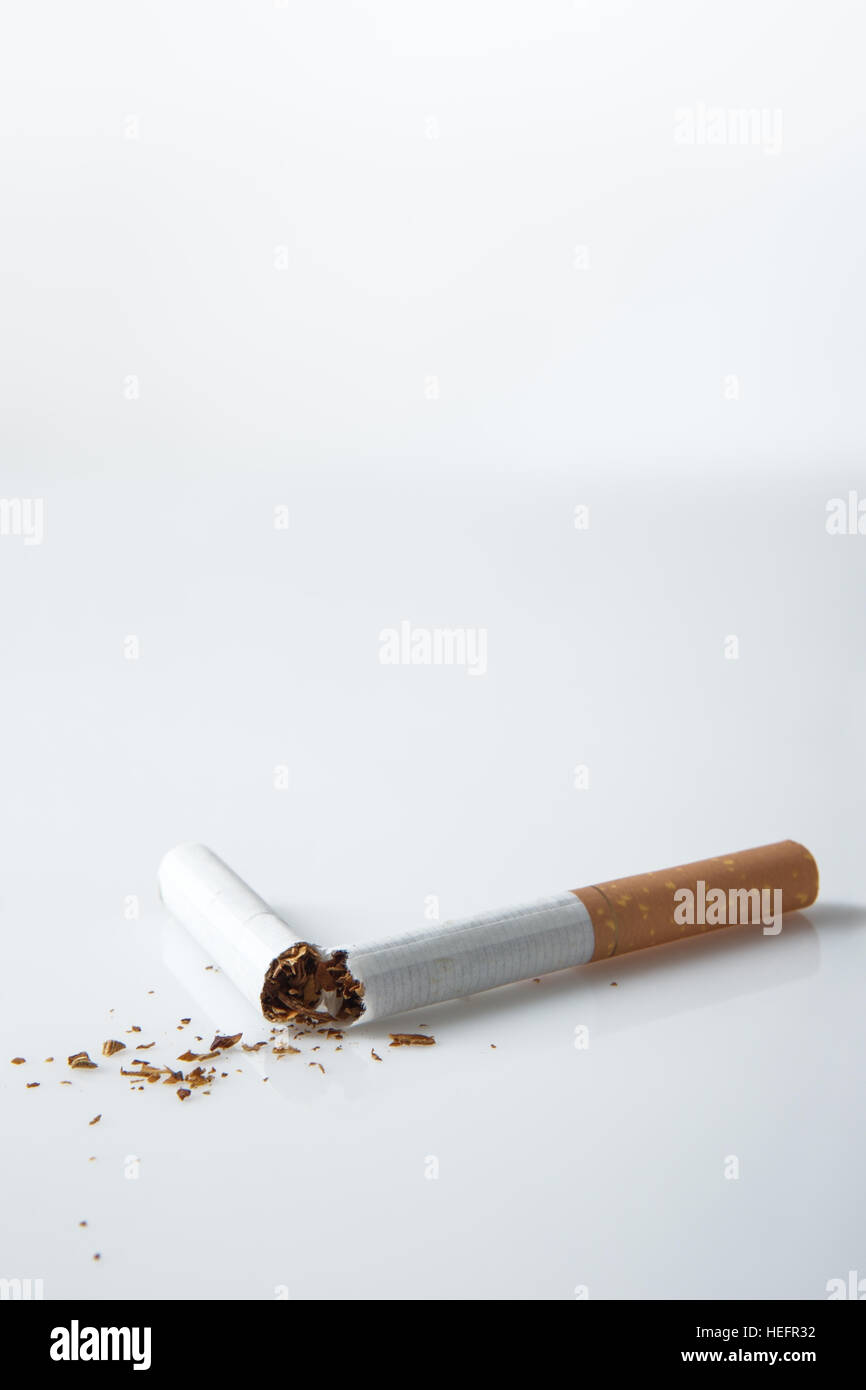 gebrochene Zigarette auf weißem Hintergrund zur Raucherentwöhnung symbolisieren Stockfoto