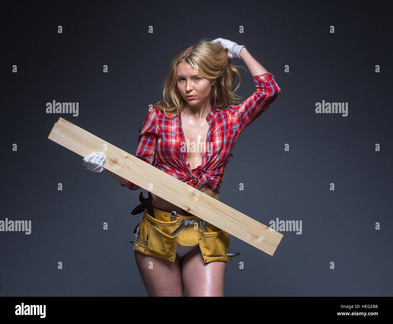 Porträt der jungen weiblichen Bau Schreiner Arbeiter mit Bleistift und Holzbrett auf Arm Stockfoto