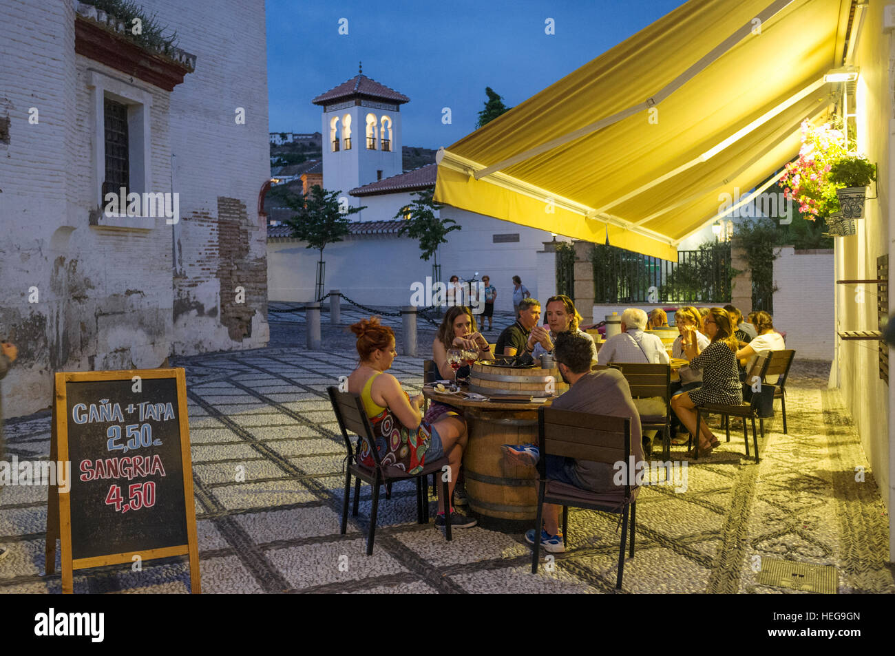 Touristen in einer OutdoorBar in der Nacht mit Minarett im Hintergrund