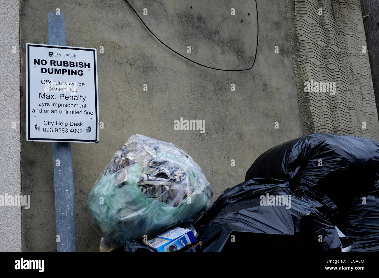 eine Müll gefüllt überspringen neben einem Schild mit der Aufschrift keinen Müll dumping England uk Stockfoto