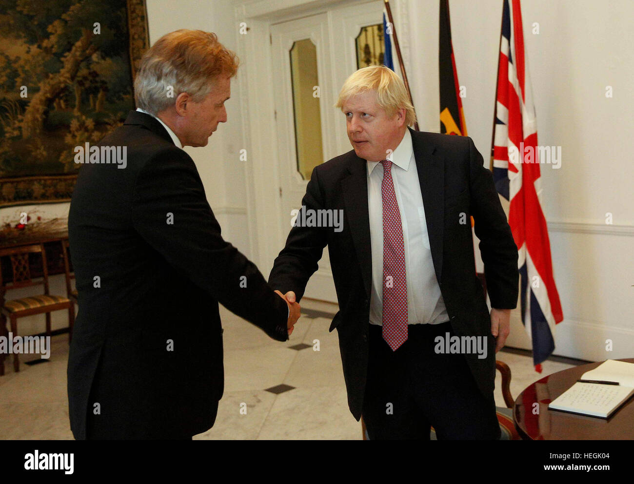 Der deutsche Botschafter Peter Ammon schüttelt Hände mit Außenminister Boris Johnson, nachdem er ein Buch der Anteilnahme für die Opfer des Angriffs LKW Berlin an der deutschen Botschaft in London unterzeichnet. Stockfoto