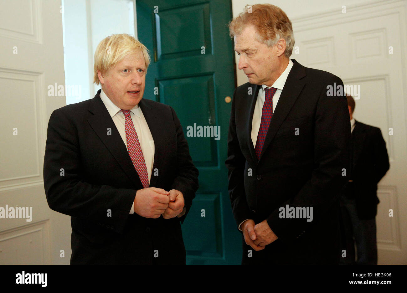 Deutscher Botschafter Peter Ammon grüßt Außenminister Boris Johnson, wie er ankommt, um ein Buch der Anteilnahme für die Opfer des Angriffs LKW Berlin an der deutschen Botschaft in London zu unterzeichnen. Stockfoto