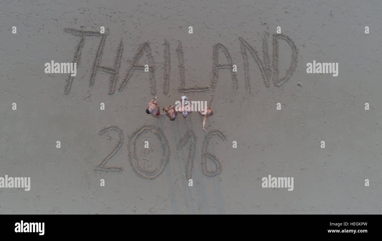 Ansicht von oben Foto von Menschen stehen am tropischen Strand mit 'Thailand 2016"in Sand geschrieben. Menschen im Urlaub die Drohne Uo betrachten und winken. TR Stockfoto