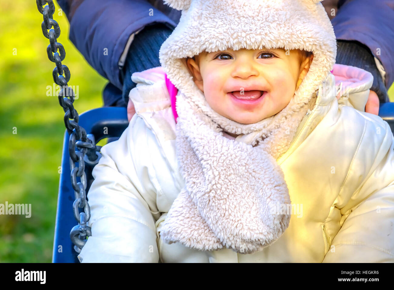 Neugeborenen Schaukel Baby Lächeln Winterspaß spielen Park Spielplatz im freien Stockfoto