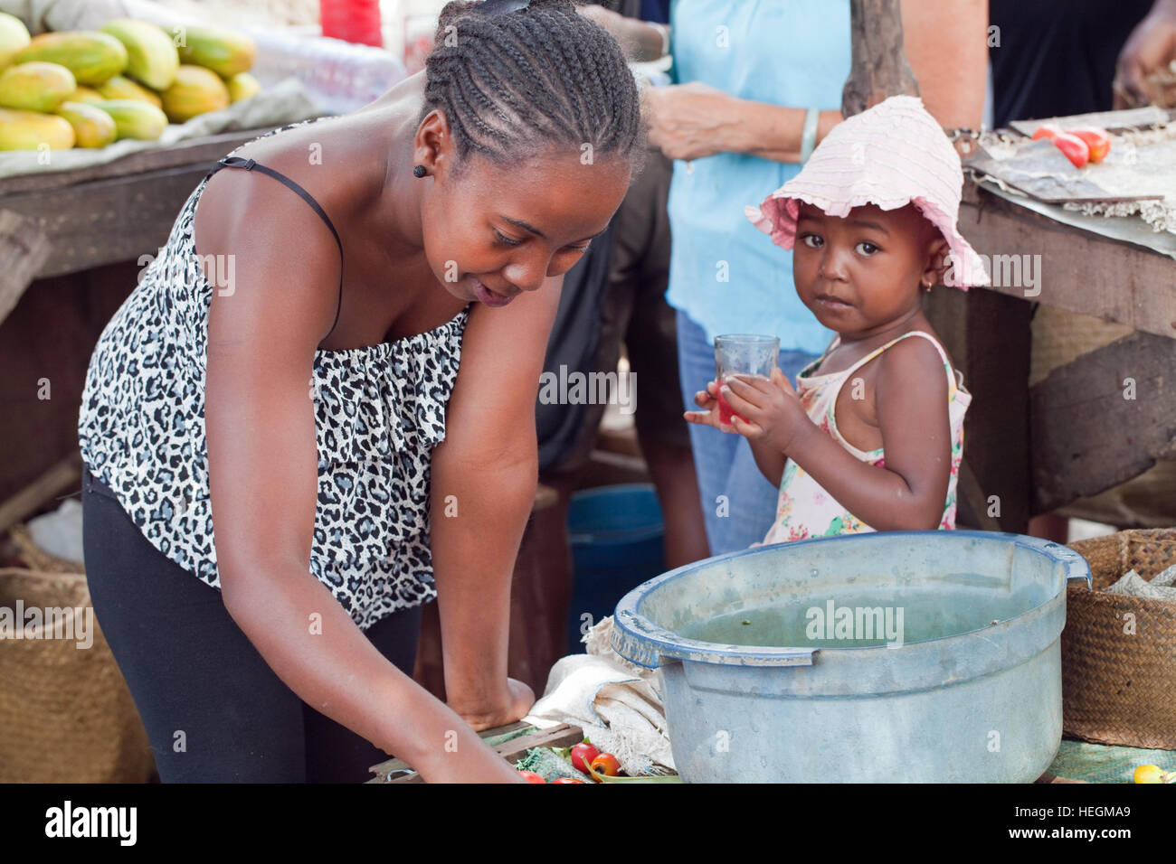 Mutter und Kind. Markt-Stall-Inhaber. Am Straßenrand Markt. Sambava. Nordostküste. Madagaskar. Stockfoto