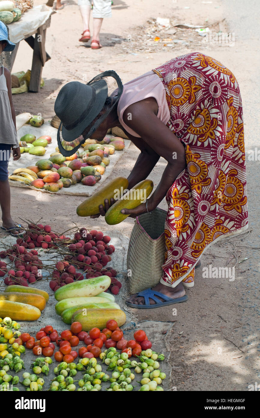 Marktstand. Obst und Gemüse. Frau macht eine Wahl aus Auswahl. Am Straßenrand Markt. Sambava. Nordostküste. Madagaskar. Stockfoto