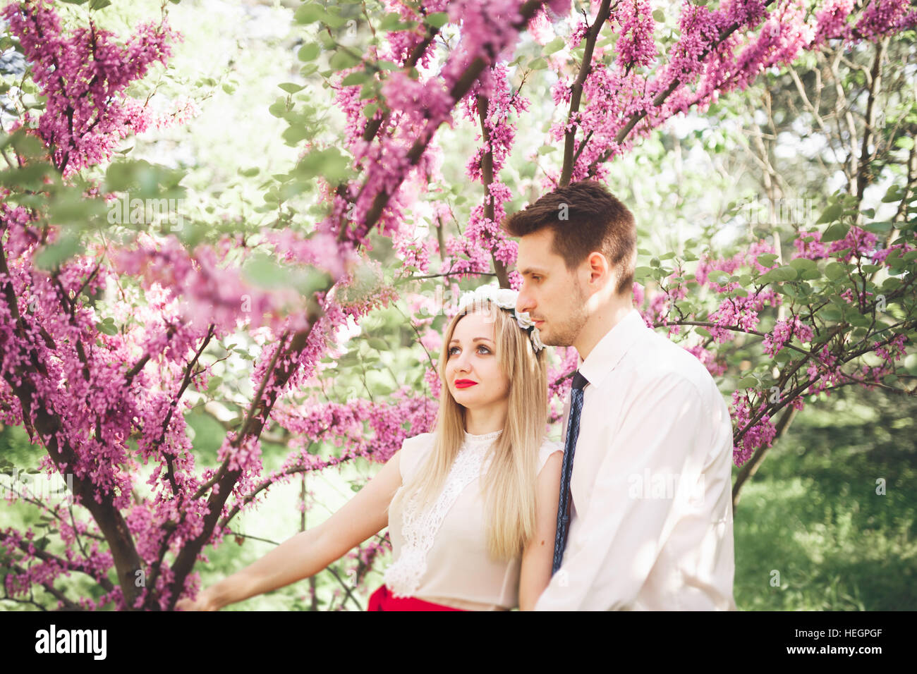 Stilvolle schöne glückliche Hochzeit paar küssen und umarmen im Botanischen Garten Stockfoto