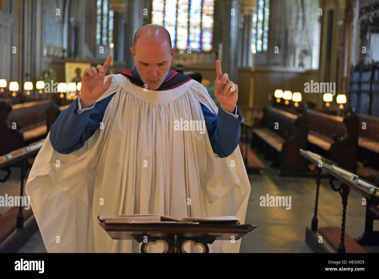 Chorleiter von Wells Cathedral Choir Proben für Abendandacht Chorknabe Pflicht in den Chor in der Wells Cathedral. Stockfoto
