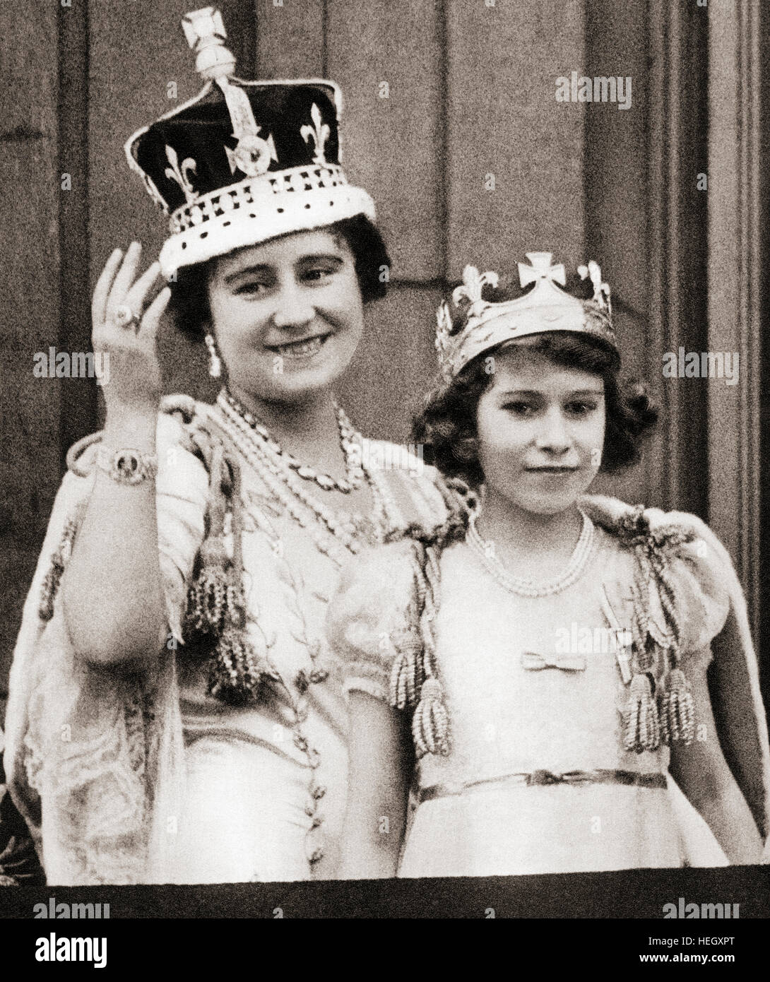Königin Elizabeth am Tag ihrer Krönung 1936 mit ihrer Tochter Prinzessin Elizabeth auf dem Balkon des Buckingham Palace, London, England. Elizabeth Angela Marguerite Bowes-Lyon, 1900–2002. Prinzessin Elizabeth, zukünftige Königin Elizabeth II.. Elizabeth II, 1926 - 2022. Königin des Vereinigten Königreichs, Kanada, Australien und Neuseeland. Stockfoto