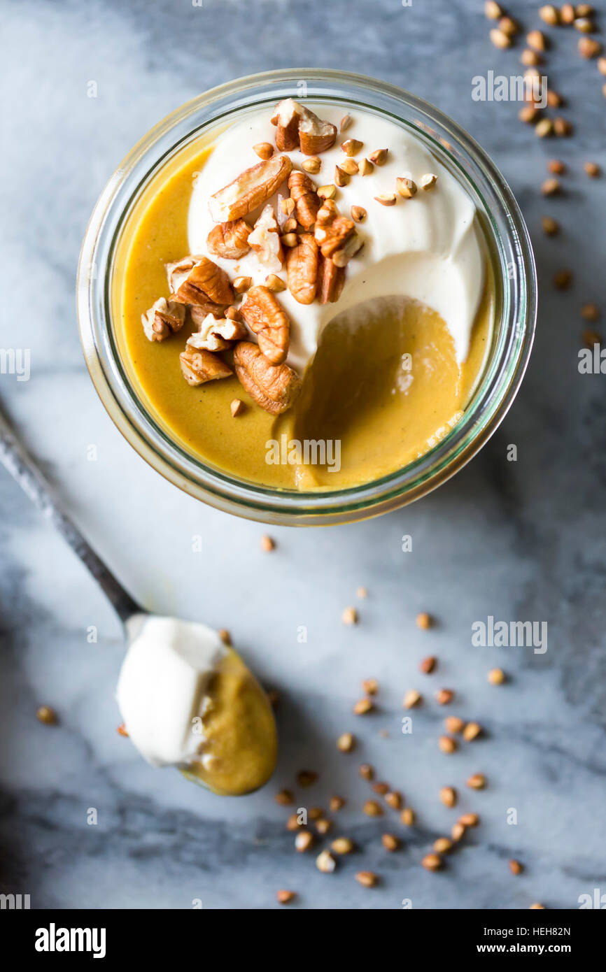 Kürbis-Butterscotch Pudding mit Schlagsahne Mascarpone und gerösteten Buchweizen Stockfoto