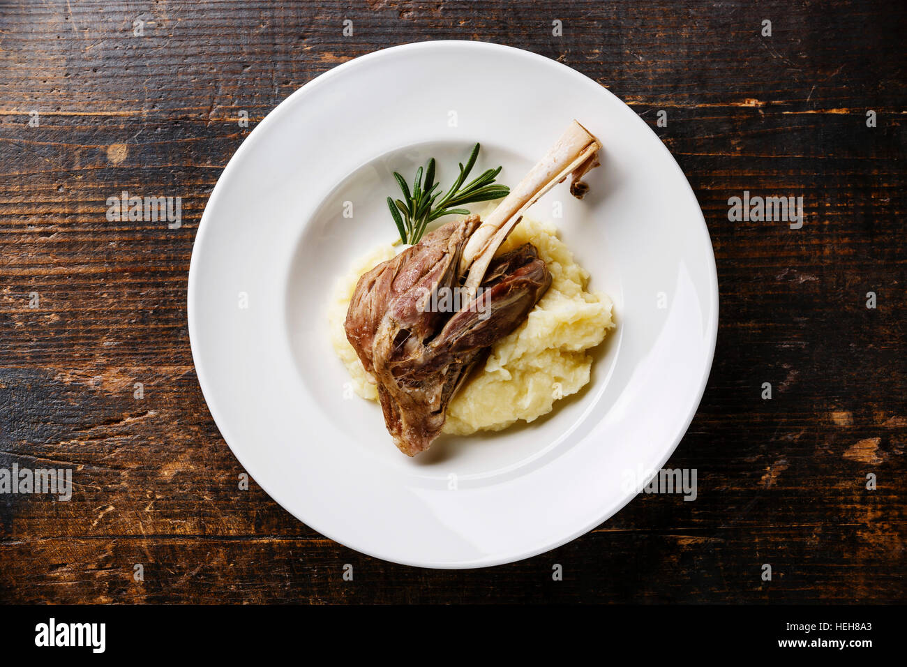 Lamm auf Knochen und Stampfkartoffeln Kartoffeln in Platte auf hölzernen Hintergrund-Eintopf Stockfoto