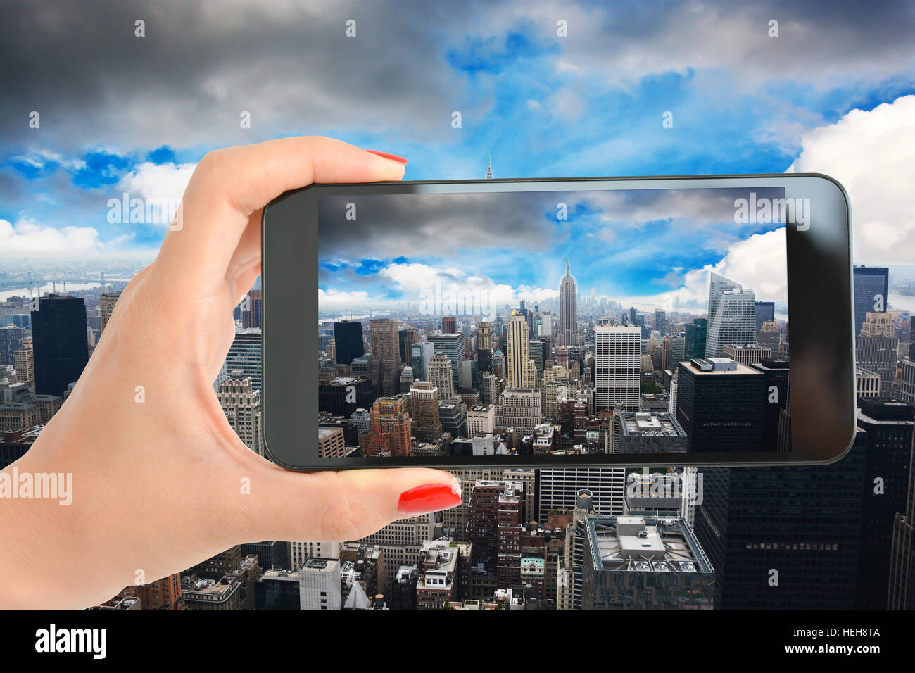 Touristischen Hand ein Bild von Manhattan und Empire State Building mit smartphone Stockfoto