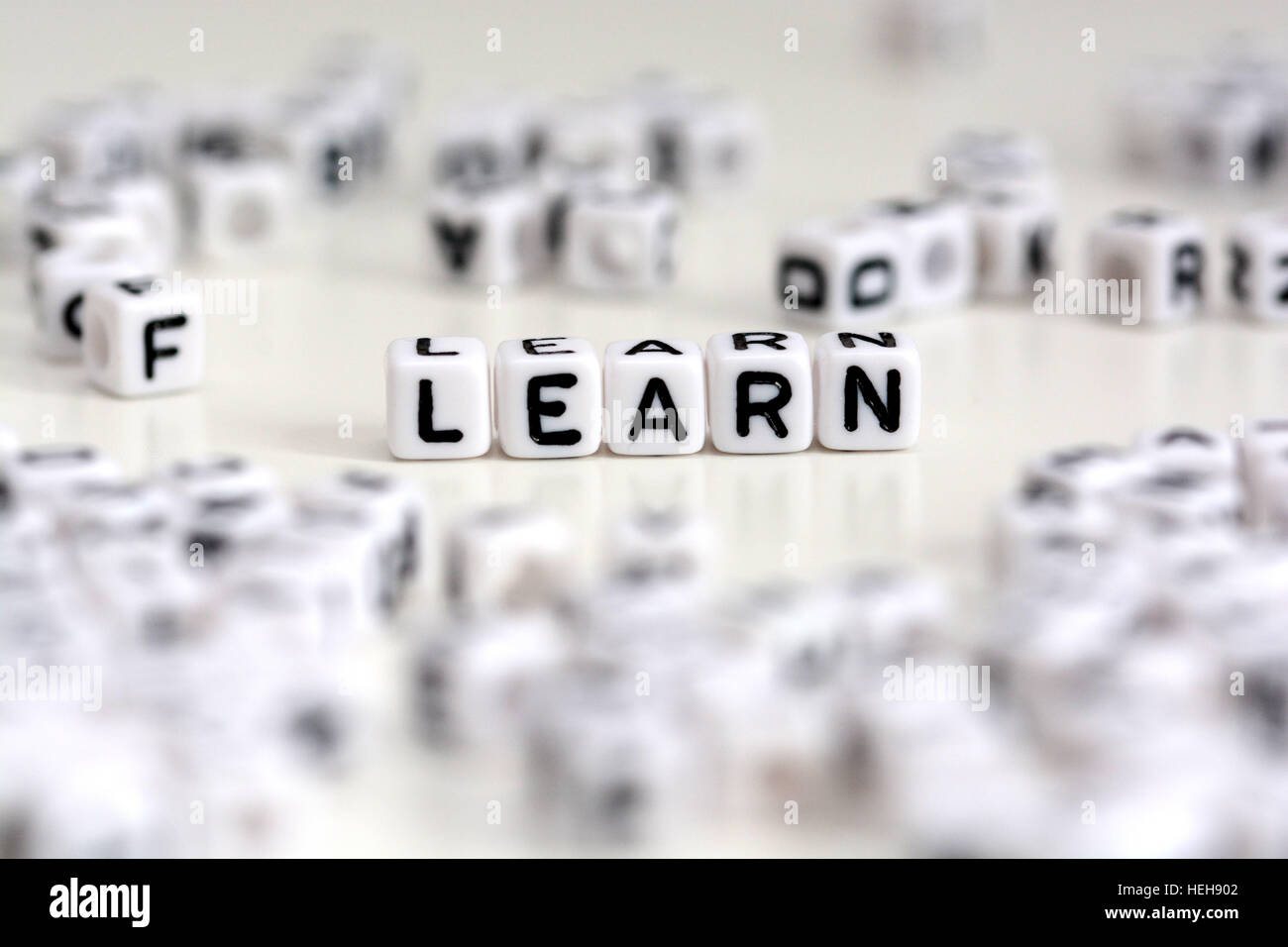 Kunststoff-Würfel Buchstaben bilden das Wort lernen auf weißem Hintergrund Stockfoto