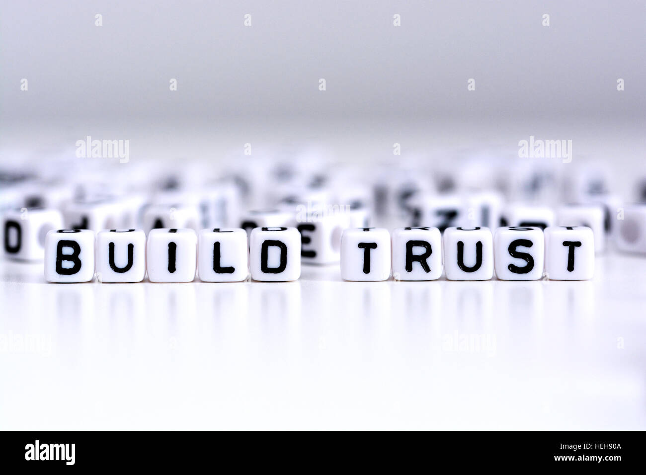 Bauen Sie Vertrauen Verfahrenskonzept mit gefliesten Buchstaben auf weißem Hintergrund Stockfoto