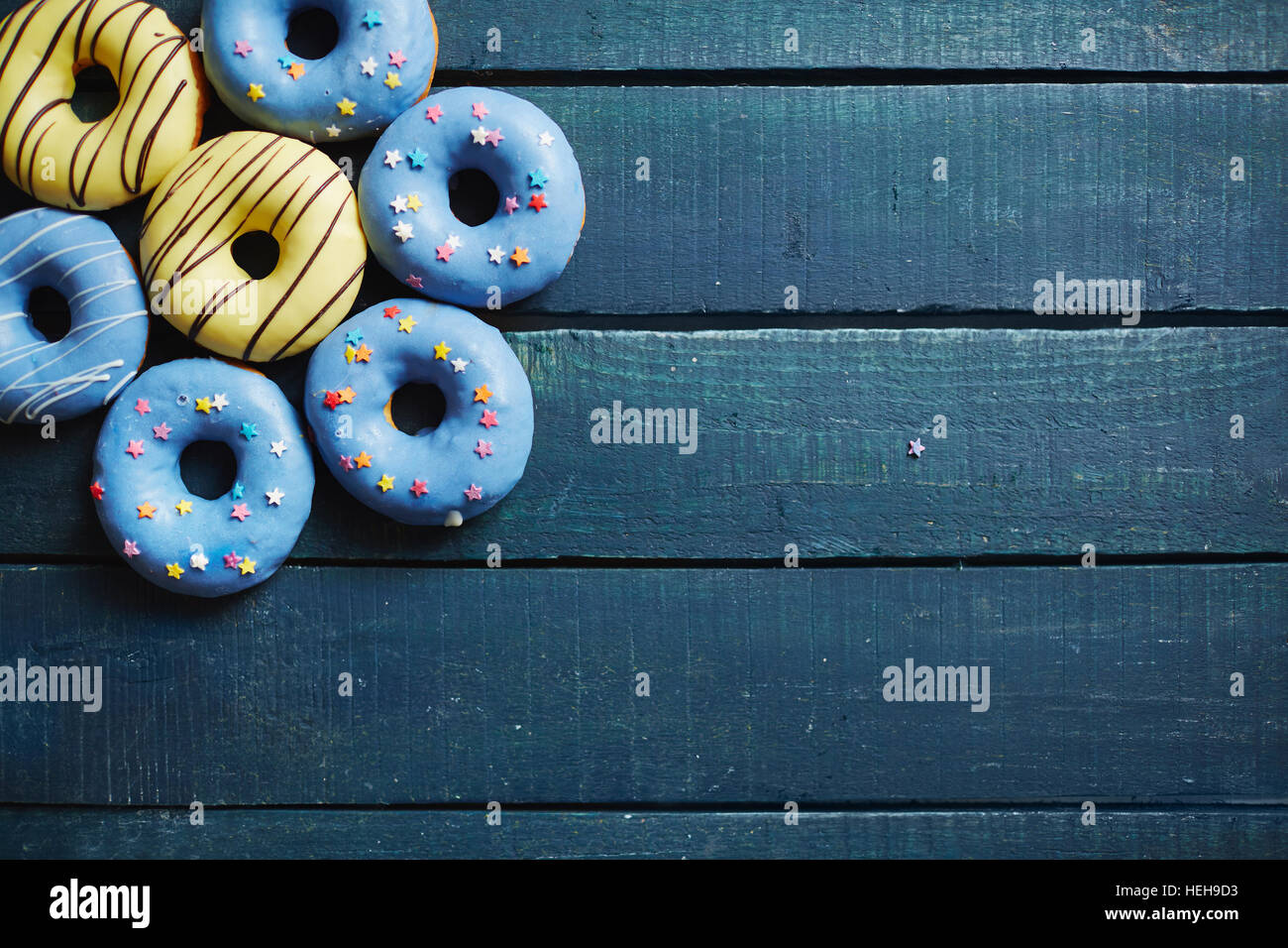 Blaue Holztafeln mit Gruppe leckere Donuts an der Spitze Stockfoto