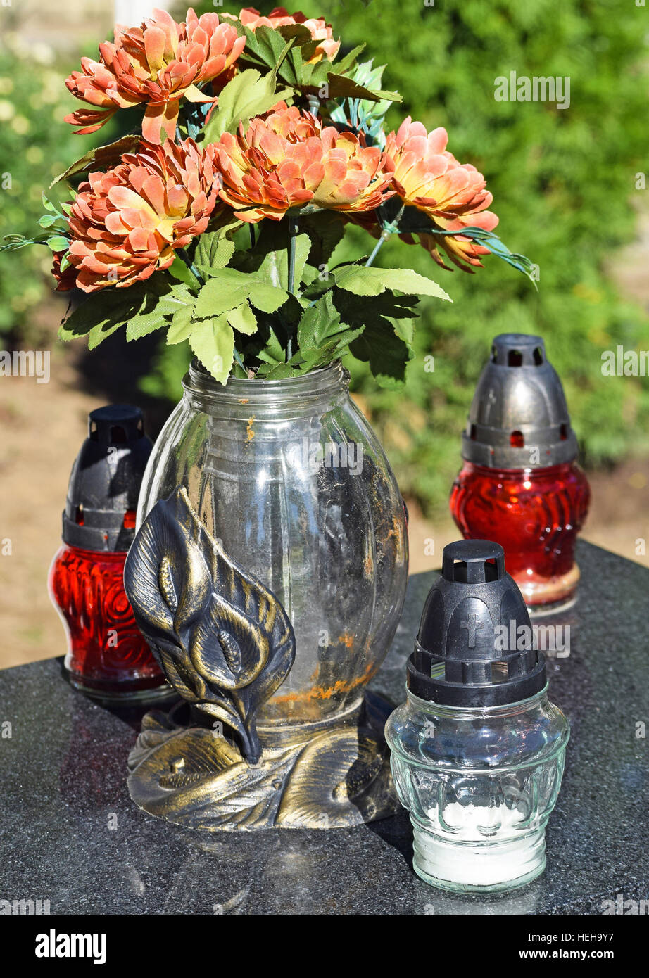 Laternen und Blumen auf dem Grabstein auf dem öffentlichen Friedhof Stockfoto