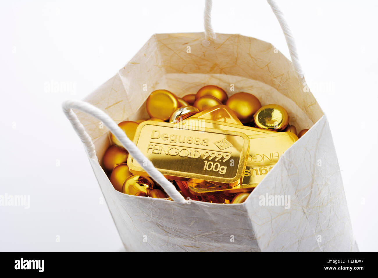 Goldbarren und Nuggets in einer Einkaufstasche Stockfoto