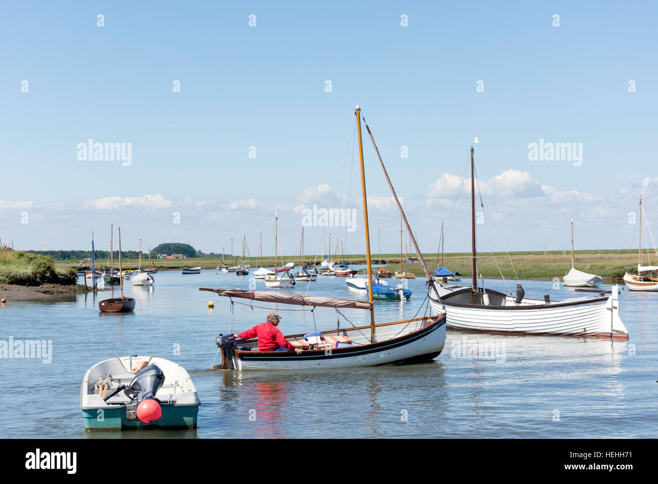 Mann traditionellen Segelboot am Fluss brennen, The Quay, Burnham Overy Staithe, Norfolk, England, Vereinigtes Königreich Stockfoto