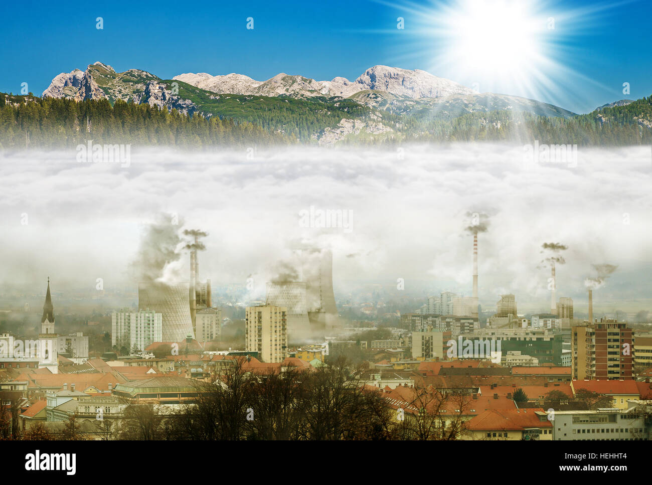 Stadt im Smog, Berge mit Sonne Stockfoto