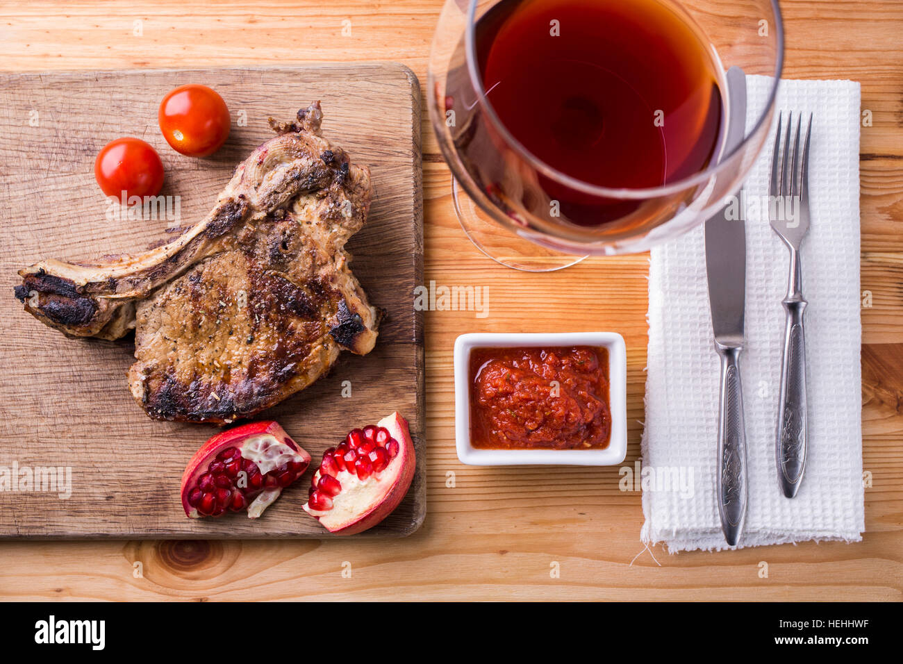 Rib-Eye Steak auf Schneidebrett mit Glas Wein Stockfoto