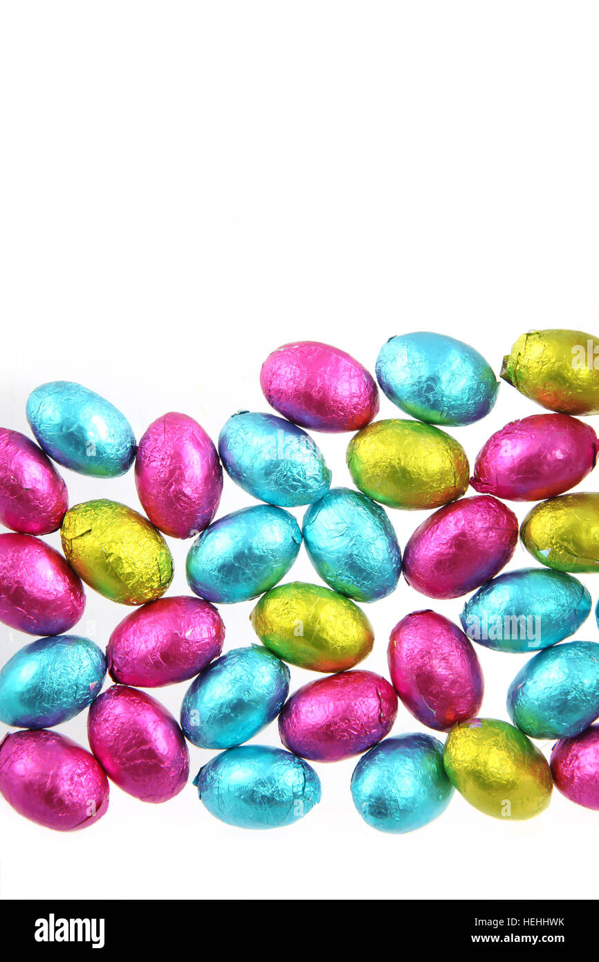 Haufen von Folie eingewickelt Schokoladeneier in rosa, blau & lindgrün mit einem weißen Hintergrund. Stockfoto