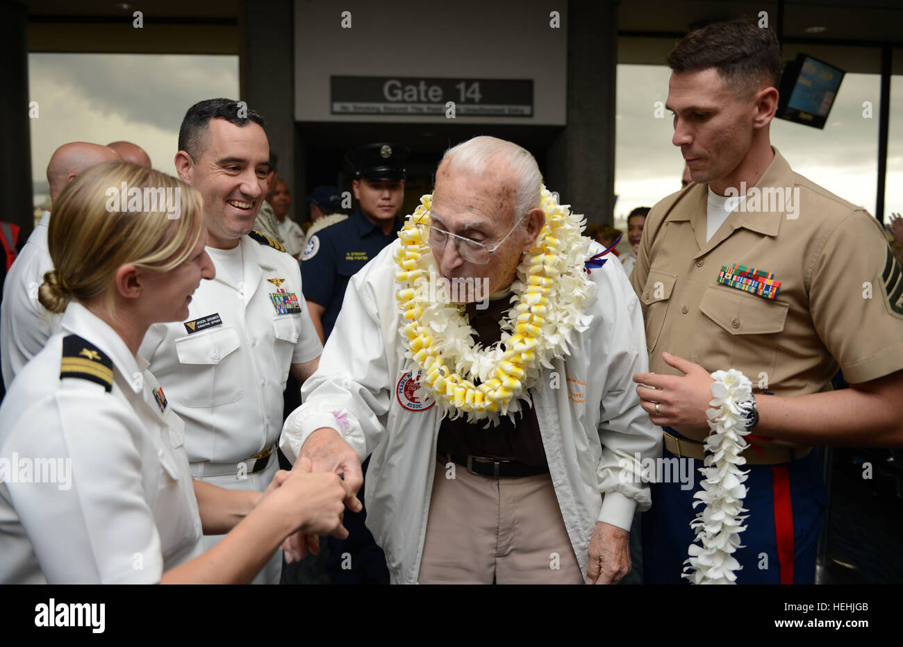 Eine Veteran des zweiten Weltkriegs Pearl Harbor USA wird von US-Soldaten mit floralen Leis begrüßt, nach der Ankunft am internationalen Flughafen Honolulu zur Teilnahme an Veranstaltungen zum Gedenken zu Ehren des 75-jährigen Bestehens des Pearl Harbor Angriffen 3. Dezember 2016 in Honolulu, Hawaii. Stockfoto