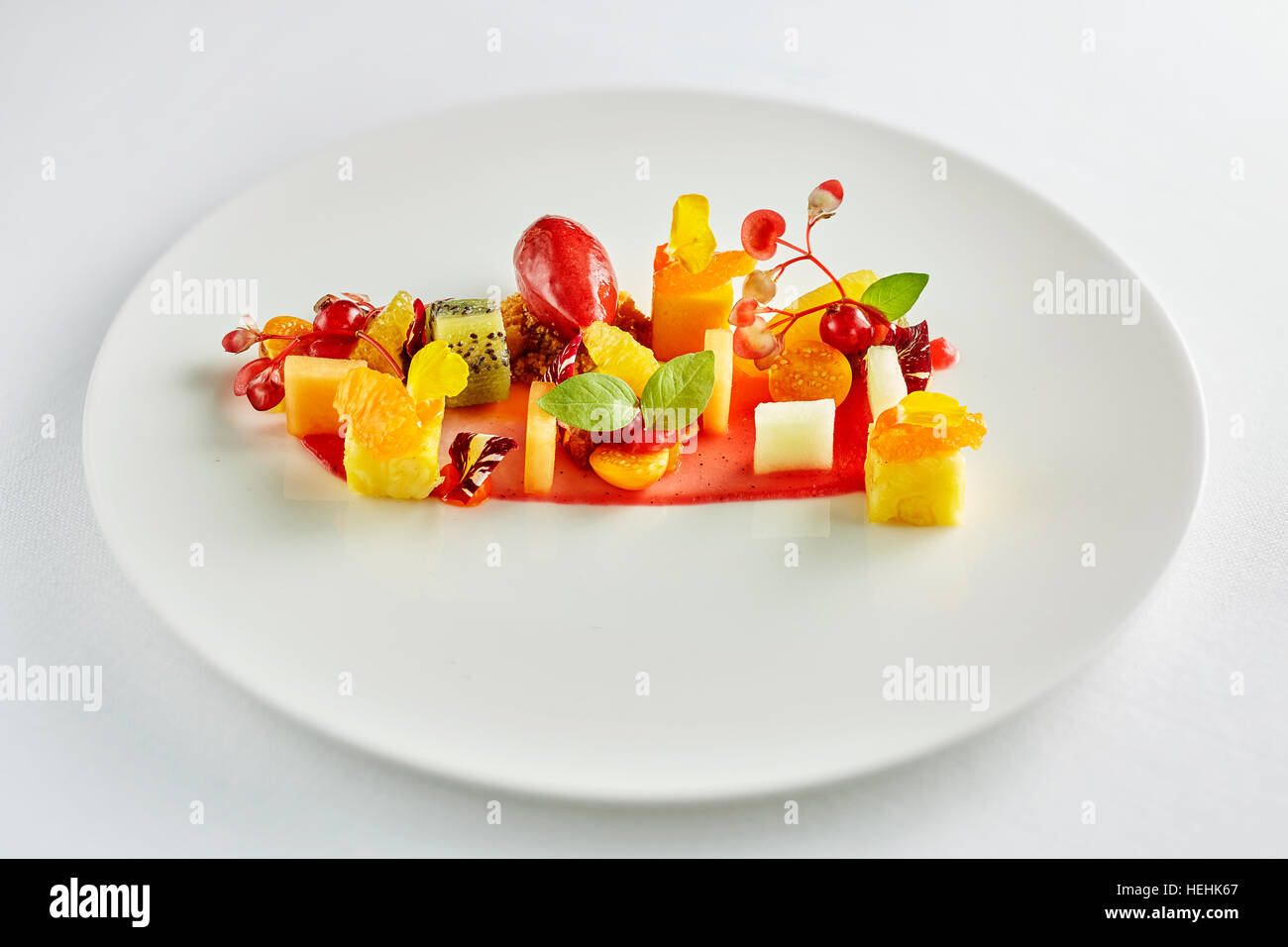 Wunderbarer Obstsalat kreativ schön zubereitete Ananas Birne Kiwi orange Erdbeere Stockfoto