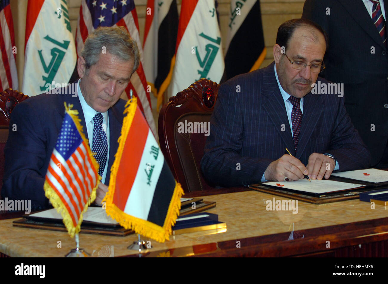 US-Präsident George W. Bush und Kamel der irakische Ministerpräsident Nuri al-Maliki unterzeichnen diplomatische Dokumente in Bagdad, Irak am Sonntag, den Schlussabstimmungen 14th, 2008. Bush Irak besucht, trifft Maliki 136588 Stockfoto