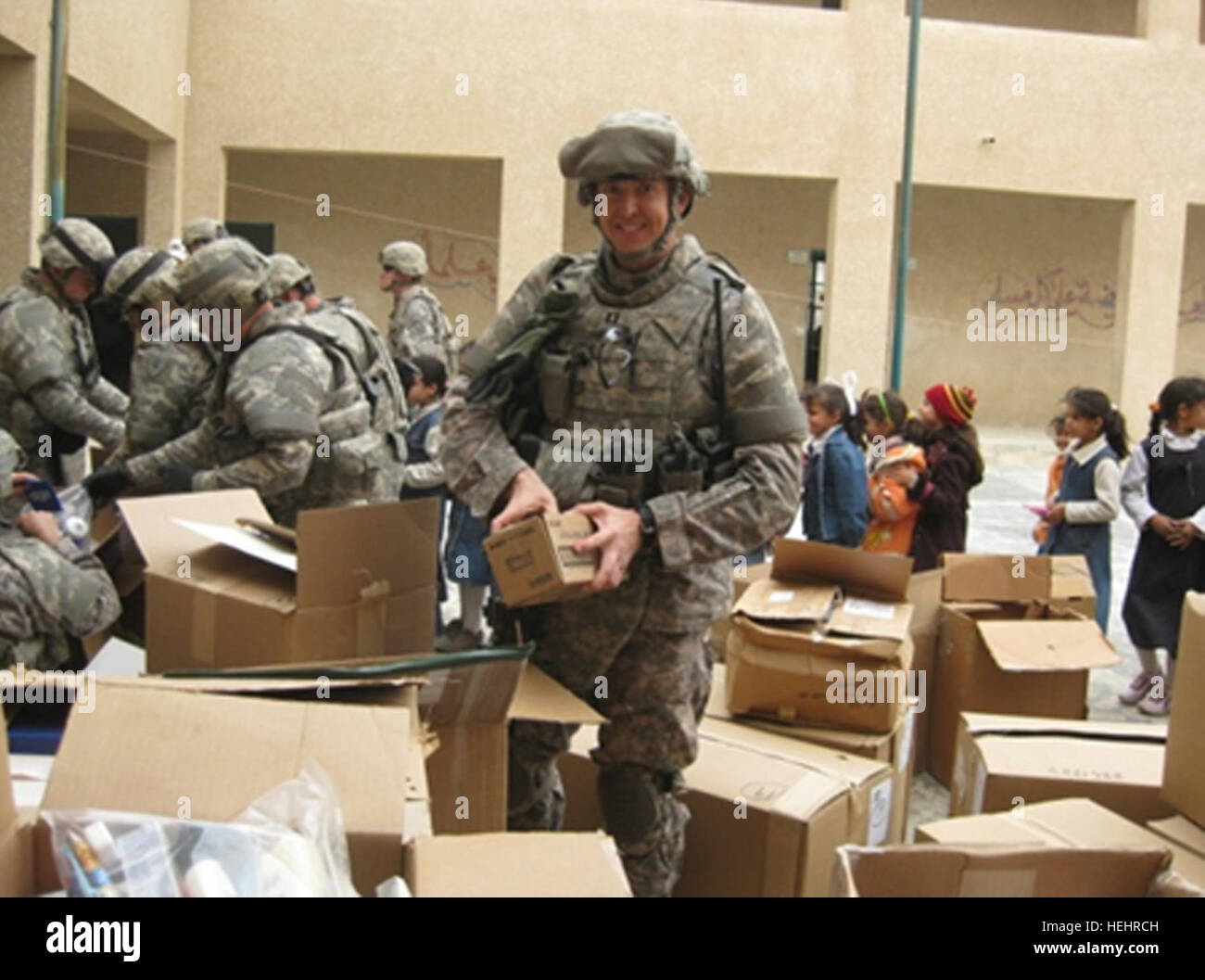 Capt Delaney Pughe, gebürtig aus Canoga Park, Kalifornien, und Geheimdienst-Offizier für die 419th bekämpfen Sustainment Support Battalion, 10. Sustainment Brigade entpackt Verteilung Elemente, wie die Kinder mit Spannung warten. 419th Bekämpfung Sustainment Support Battalion in gutem Willen mission für eine lokale irakische Mädchen Schule 154449 Stockfoto