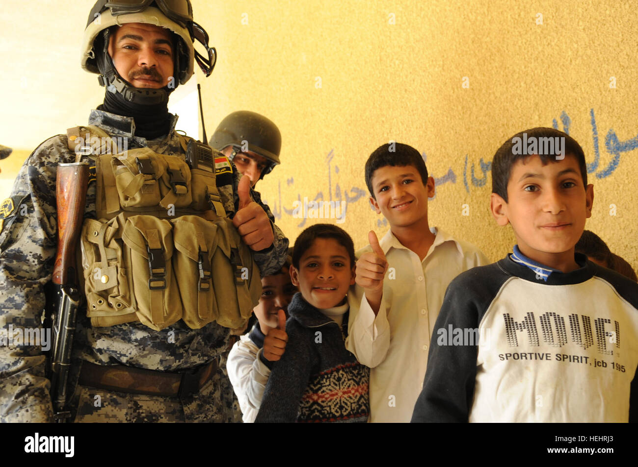 Eine irakische nationale Polizist und irakischen Jungen geben einen Daumen hoch an einer Schule in Shawra Wa Umm Cıdır, östlichen Bagdad, Irak, am 8. März. Irakische Nationalpolizei und US-Soldaten der Bravo Company, 2. Bataillon, 505. Fallschirm-Infanterie-Regiment, 3rd Brigade Combat Team, 82nd Airborne Division, besuchen Schulen, Hilfsgüter verteilen. Soldaten, irakische nationale Polizisten verteilen Schulmaterial in Bagdad 157199 Stockfoto