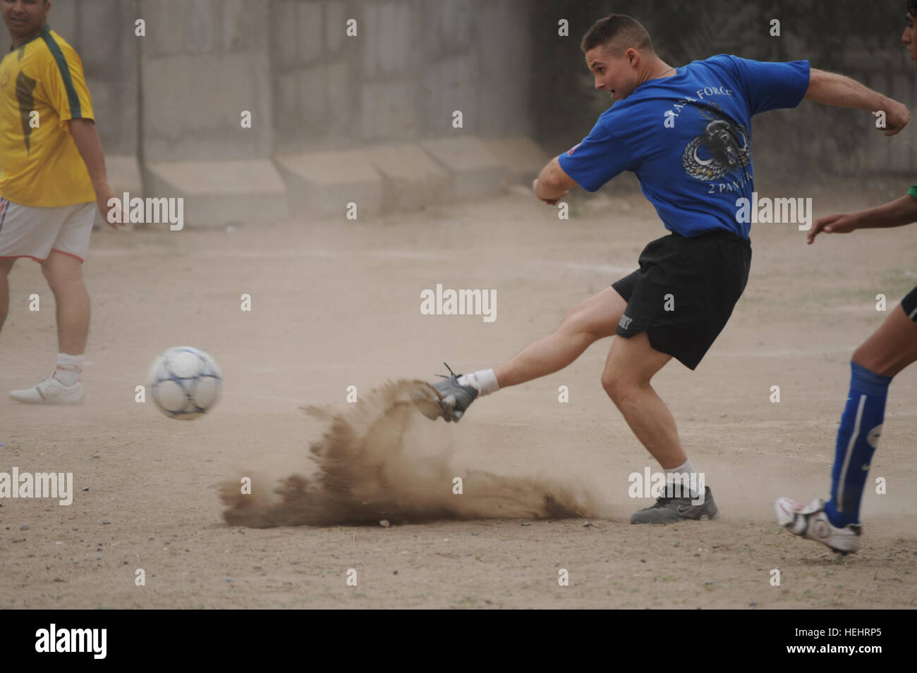 Ein US-Soldaten des 2. Bataillon, 505. Fallschirm-Infanterie-Regiment, 3rd Brigade Combat Team, 82nd Airborne Division, kickt den Ball und schürt eine Wolke aus Staub in einem Freundschaftsspiel der Fußball zwischen irakischen Arbeitnehmer und US-Soldaten am gemeinsamen Sicherheit Station Obaidey im östlichen Bagdad, Irak, am 9. März. Fussball im Joint Security Station Obaidey 157329 Stockfoto