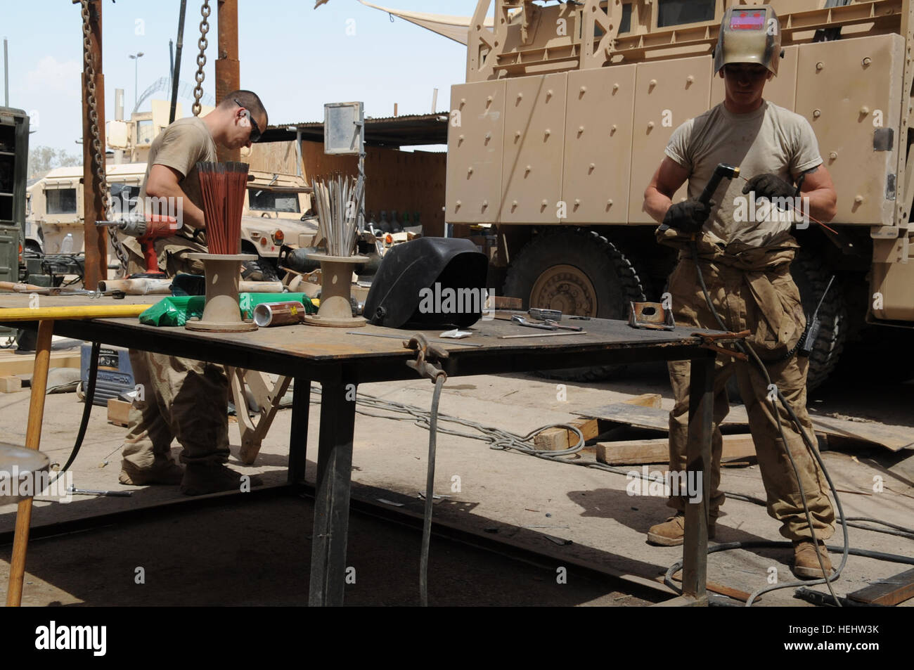US Armee Sgt. Marty Vaughan (rechts) aus Roxboro, N.C., 2. Bataillon, 505. Fallschirm-Infanterie-Regiment, 3rd Brigade Combat Team, 82nd Airborne Division, installiert einen Schweißstab in ein Schweißgerät in Vorbereitung, um Stücke von einer Halterung am 10. April bei einer Reparatur auf eine Mine Resistant Ambush Protected Fahrzeug am gemeinsamen Sicherheit Station Loyalität, östlichen Bagdad, Irak, verschweißen. Kfz-Instandsetzung in Bagdad, Irak 166070 Stockfoto