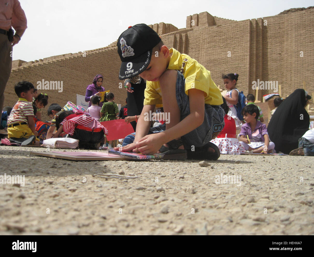 Kindergarten Studenten aus Mumsuna Schule in Nasiriyah, Irak, komplette Kunstwerke während der Teilnahme an einer Zeremonie anlässlich der Übertragung der Zikkurat von Ihr aus den USA zu irakischen kontrollieren. Die Zikkurat war seit 2003 für die Öffentlichkeit geschlossen. Die Zeremonie nahmen irakische Regierung und militärische Vertreter von Multi-National Division - Süd. Die Zikkurat wurde durch Ihre sumerische König-Nammu 2100 v. Chr. erbaut. Multi-National Division - Süd Führer besuchen Zeremonie im Zikkurat von Ihrem 171882 Stockfoto