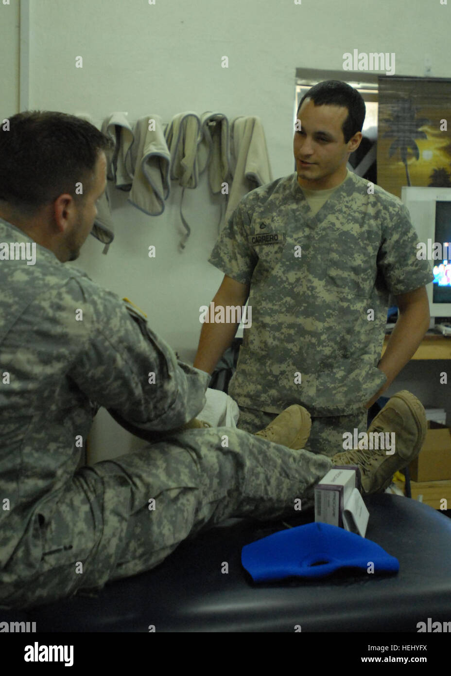 PFC. Wilson Carrero, von Lancaster, Pennsylvania, ein Physiotherapeut Assistent mit Firma C 'Charlie Med,"328. Brigade Support Battalion, 56. Stryker Brigade Combat Team, bietet ein Patient mit einer Knieorthese und einige Anweisungen, 13 Juni, am Camp Taji, Irak, nördlich von Bagdad. 'Charlie Med' Soldaten Camp Taji kümmern, halten Sie Ausschau nach einander 179758 Stockfoto