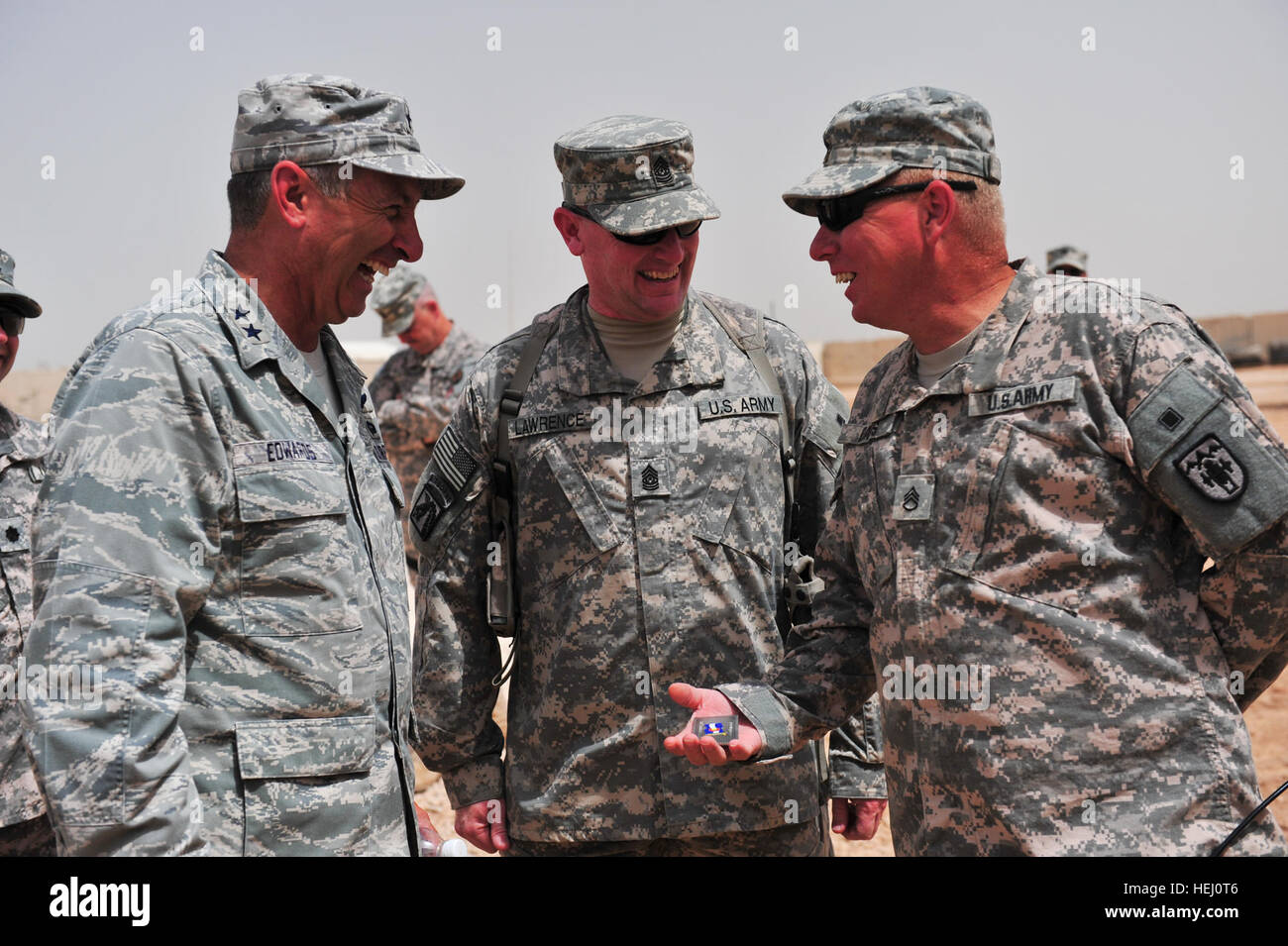 Staff Sgt Roger Davis von der 188. vorwärts Unterstützungskompanie, 3. Bataillon, lacht 157. Feldartillerie, Colorado Army National Guard mit Kolorados Besuch von Führungskräften, Generalmajor H. Michael Edwards, Colorado National Guard Generaladjutant und Command Sergeant Major Michael Lawrence, Colorado National Guard eingetragenen Führungsmitglied, über der Münze, die er vorgestellt wurde, die 23. Juli, am Camp Ramadi, Irak. Sie alle haben ein gutes Lachen, wenn jemand sagte: "Es ist zu groß, um in Ihrer Brieftasche tragen." Colorado-Führung an den feinsten 211952 Stockfoto