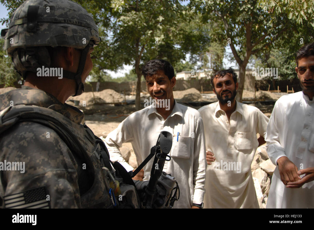 Techn. Sgt Shawn Newland, ein Statiker von Nangarhar Provincial Reconstruction Team aus nach vorne Operating Base Finley Shields, Afghanistan, im Gespräch mit den Männern, die den Ausbau von Wazir Jahdi des jungen und des Mädchens Naswan Schulen bauen.  Tech Sgt. Newland angeboten Tipps zum Mischen von Zement und festere Strukturen aufzubauen. Nangarhar Provincial Reconstruction Team auf den Bau einer Mädchenschule 191971 überprüfen Stockfoto