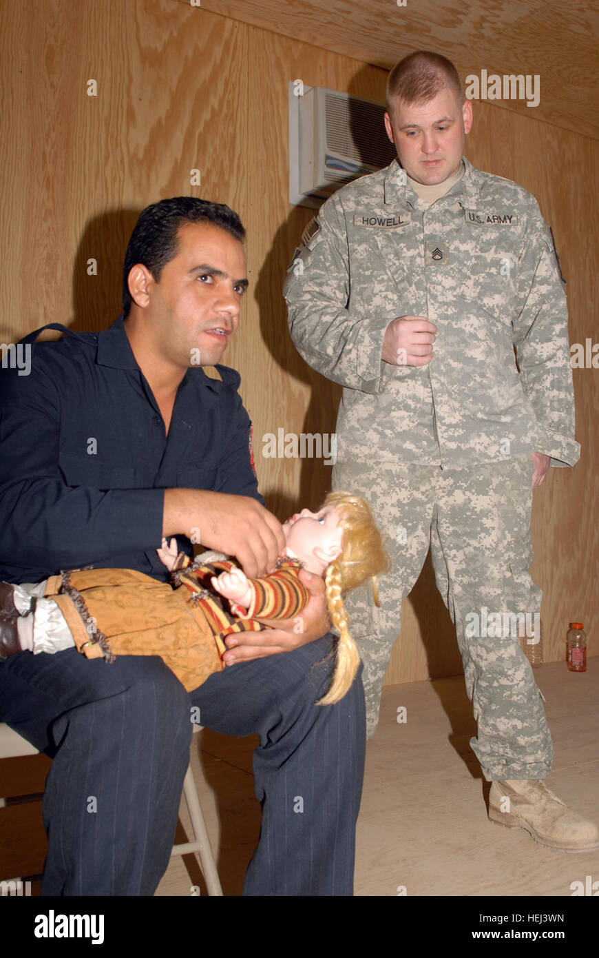 US Army 51044 Bagdad - Staff Sgt Chris Howell beobachtet eine irakische Rettungssanitäter zeigen überprüfen und löschen die Atemwege eines Kleinkindes in Atemnot, eine erste Ki eine Babypuppe mit Stockfoto