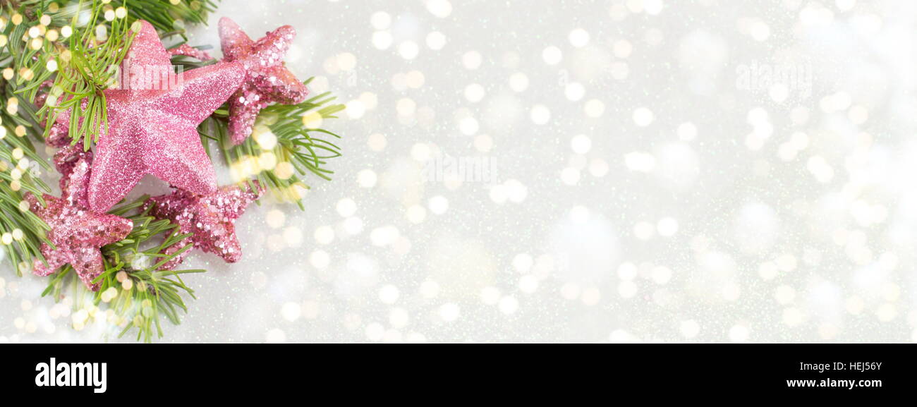 Rosa sternförmige Ornamente hängen an einer Tanne Zweig. Weihnachts-Feier-Zeit. Stockfoto
