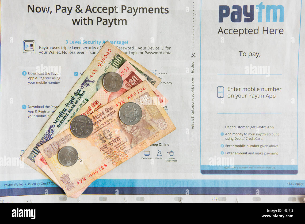 HYDERABAD, Indien - Dezember 22,2016 Zahlungen mit Paytm Zeitungsanzeige in Indien, indischer 100 Rupie-Banknoten und-Münzen Stockfoto